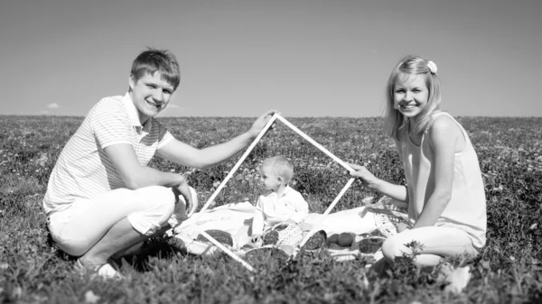 Família feliz com o filho e piquenique — Fotografia de Stock