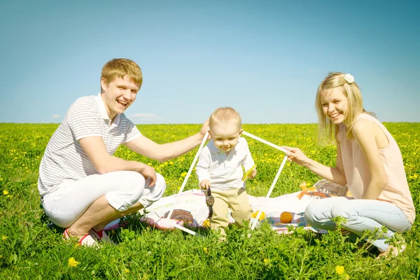 Família feliz com o filho e piquenique — Fotografia de Stock