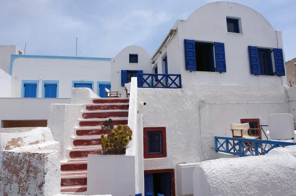 Villa met blauwe windows op santorini eiland. — Stockfoto