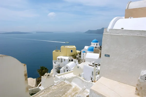 Paysage avec maisons et bateau sur l'île de Santorin . — Photo