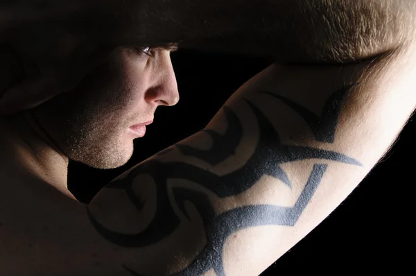 Retrato de un hombre con tatuajes en el brazo — Foto de Stock