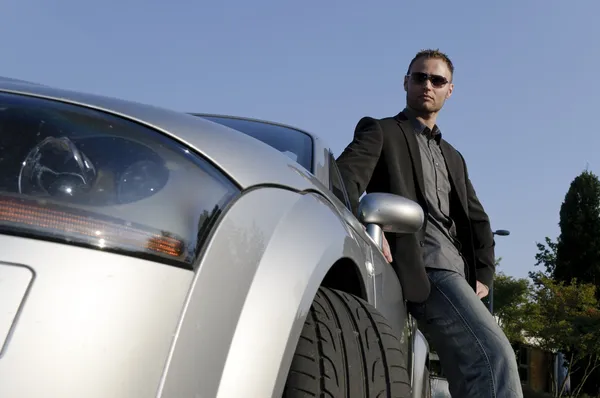 Successful businessman in front of his convertible — Stock Photo, Image