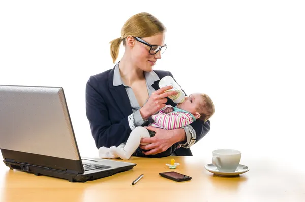 Businesswoman gives baby the bottle — Stock Photo, Image