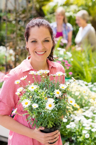 Kvinnan håller krukväxter blommor på HANDELSTRÄDGÅRDEN — Stockfoto