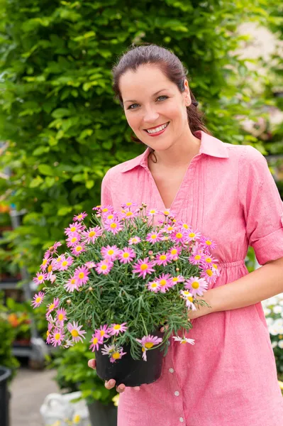 Leende kvinna håll rosa krukväxt blomma — Stockfoto