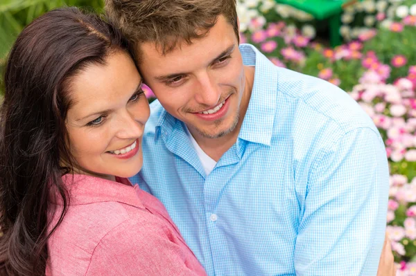 幸せなカップルの咲く庭で抱いて — ストック写真