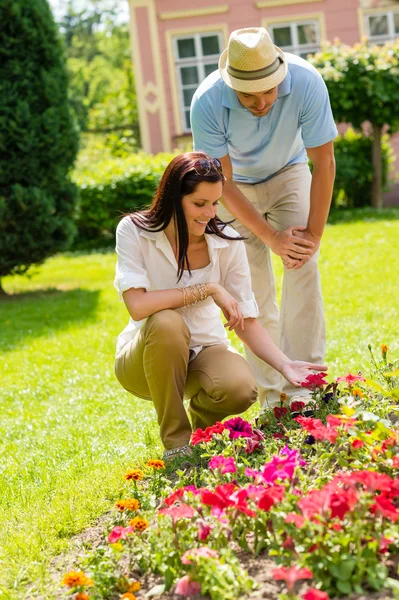 Junges Paar sucht Blumen im sonnigen Park — Stockfoto