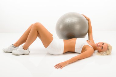 Slim blond woman exercise with fitness ball clipart