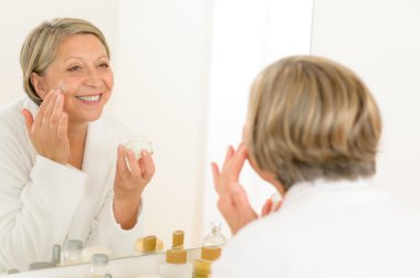 Olgun kadın uygulamak krem görünümlü banyo aynası