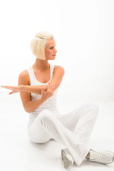 Instrutor de fitness feminino esticando os braços no branco — Fotografia de Stock
