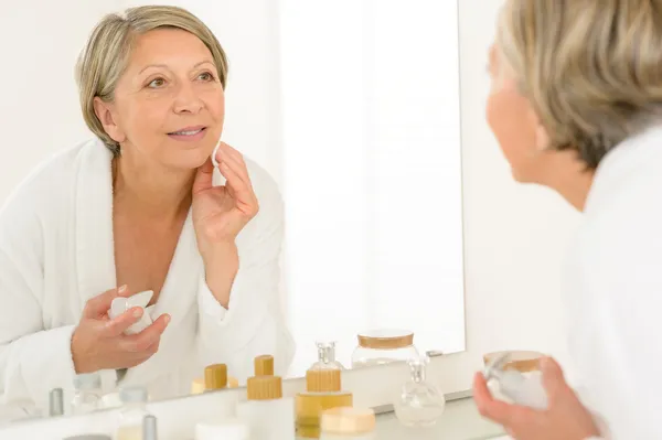 Senior femme regarder elle-même miroir de salle de bain réflexion — Photo