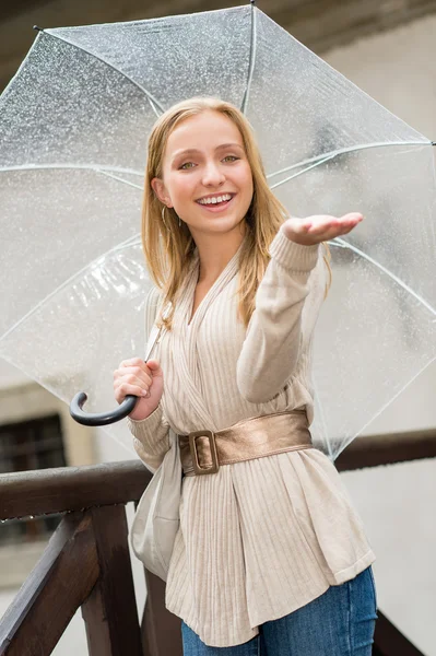 Молодая счастливая женщина под дождем с зонтиком — стоковое фото