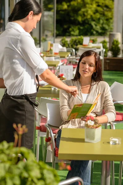 Camarera apuntando mujer menú en bar cafetería —  Fotos de Stock