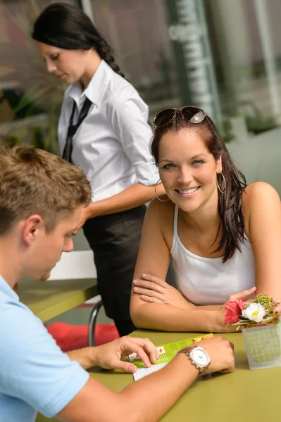 Paar im Café schaut sich Speisekarte an — Stockfoto