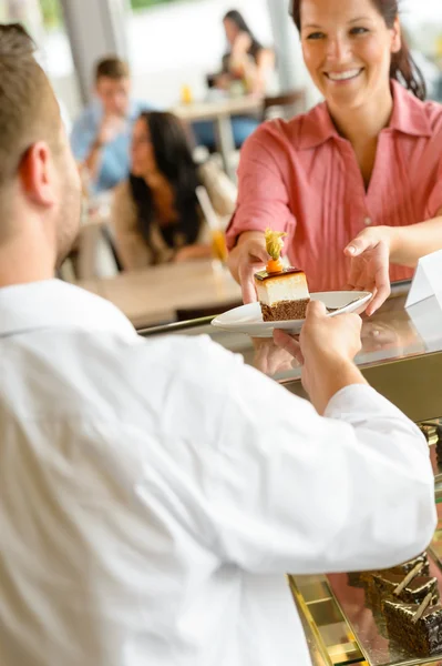 Camarero dando plato de pastel de mujer en la cafetería — Foto de Stock