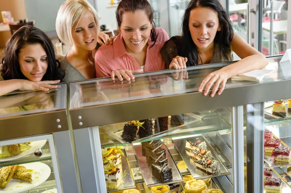 Przyjaciele kobiet patrząc na ciastka w kawiarni — Zdjęcie stockowe