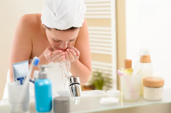 Vrouw gezicht wassen boven badkamer wastafel — Stockfoto