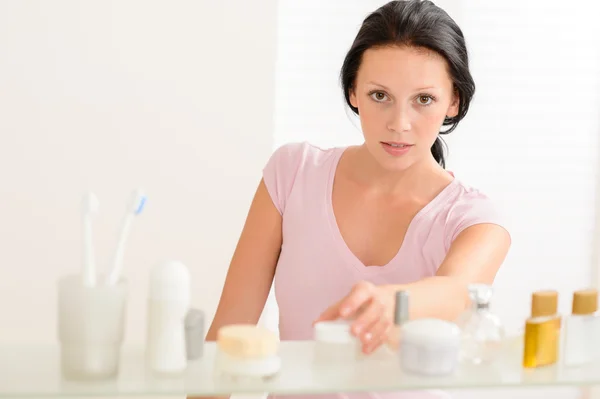 Jovem mulher tomar produtos cuidados de beleza — Fotografia de Stock