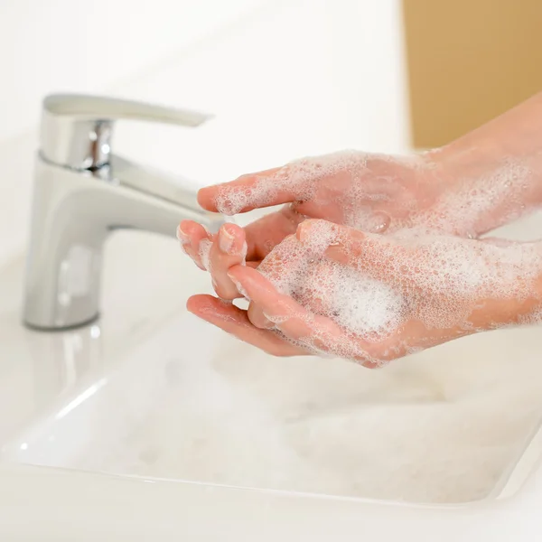 Sapone lavamani primo piano sopra il lavandino del bagno Foto Stock