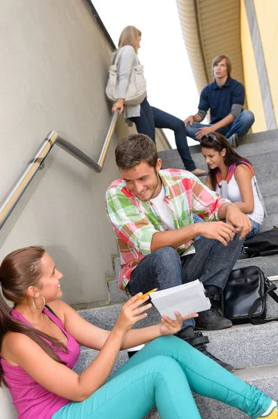 Студенты разговаривают расслабляясь на ступеньках школы подростки — стоковое фото