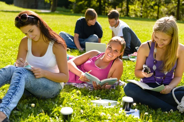 Adolescentes estudiando en el parque leyendo libros estudiantes —  Fotos de Stock