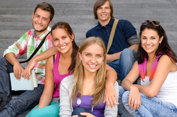 Eleverna sitter på skolan trappor leende tonåringar Stockfoto