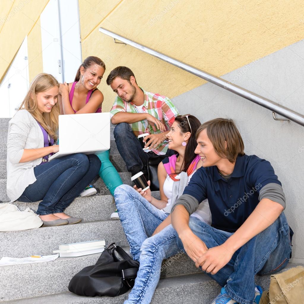 Students enjoying break on school steps laptop