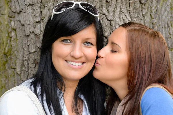 Tochter gibt ihrer Mutter draußen einen Kuss — Stockfoto