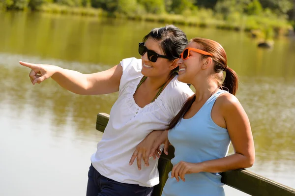 Fille et mère se détendre sur la jetée du lac — Photo