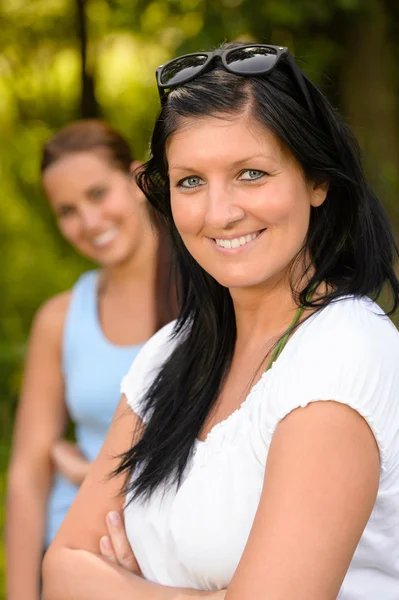 Mor leende med tonåring dotter i bakgrunden — Stockfoto