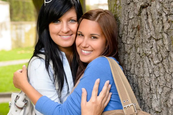Mother and teen hugging outdoors relaxing smiling Stock Photo