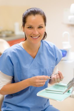 Smiling dentist woman with dental tools clipart