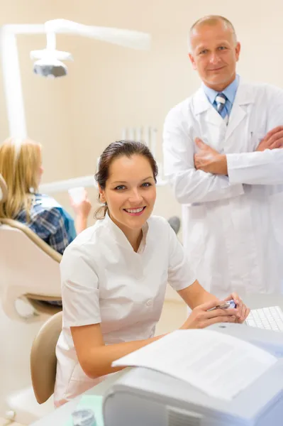 Dentysta z asystentem uśmiechający się w chirurgii stomatologicznej — Zdjęcie stockowe