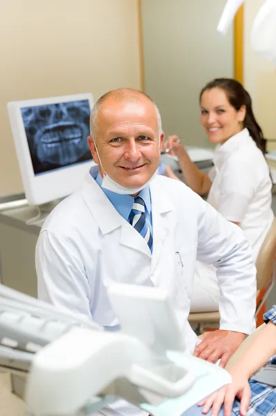 Reifer Zahnarzt im Büro mit Assistentin — Stockfoto