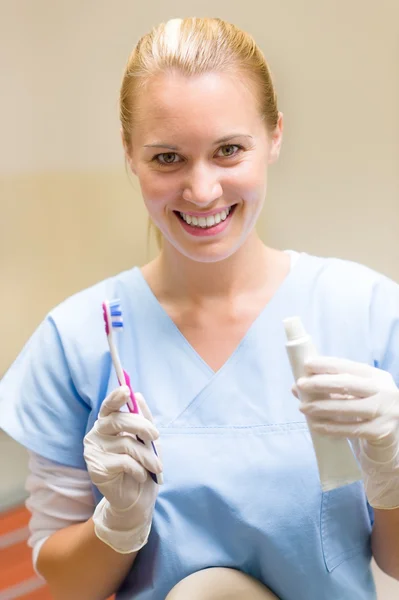 Igienista dentale tenere spazzolino da denti e dentifricio — Foto Stock