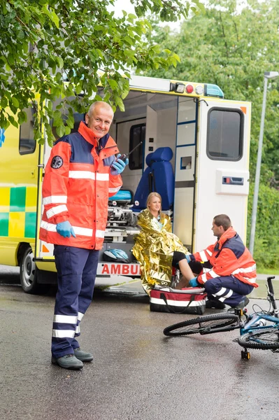 Kadın Bisiklet kazası ambulans yardımcı sağlık görevlisi — Stok fotoğraf