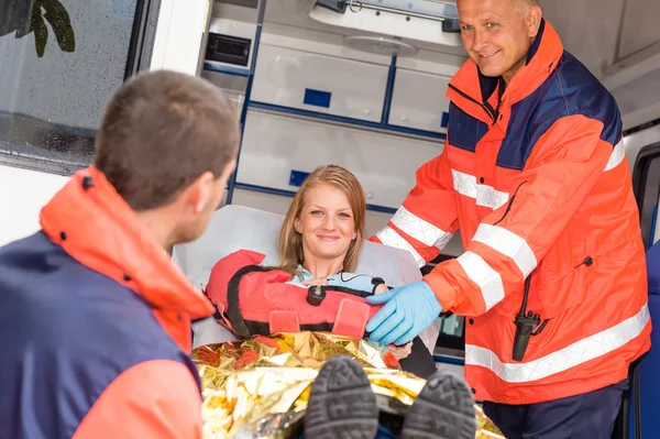 Les ambulanciers aident une femme dans une ambulance bras cassé — Photo