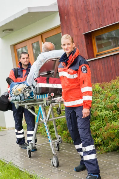 Paramedici con paziente su barella ambulanza — Foto Stock