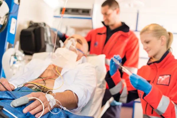 Sick patient with paramedic in ambulance treatment — Stock Photo, Image