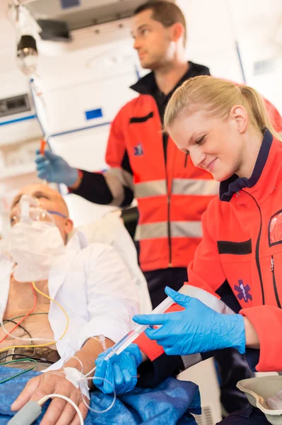 Paramedics injecting sick patient in ambulance aid — Stock Photo, Image