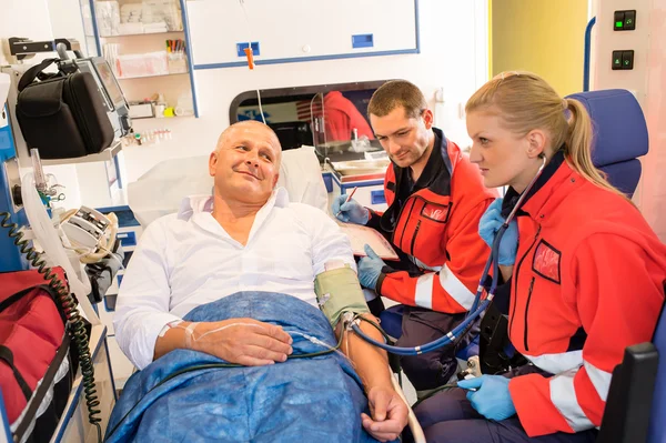 Paramédicos revisando el pulso del paciente en coche de emergencia —  Fotos de Stock