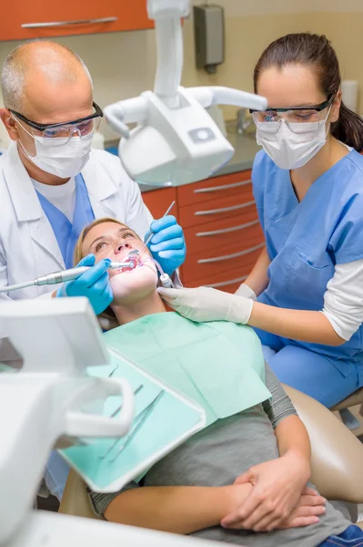 Dentista com enfermeira fazendo procedimento no paciente Imagem De Stock