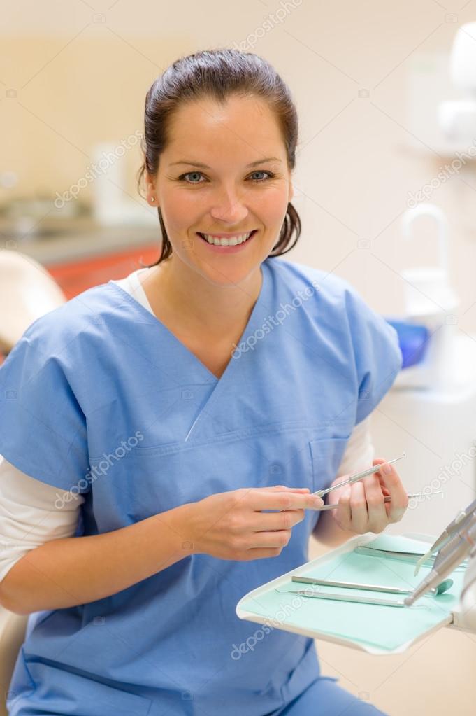 Smiling dentist woman with dental tools