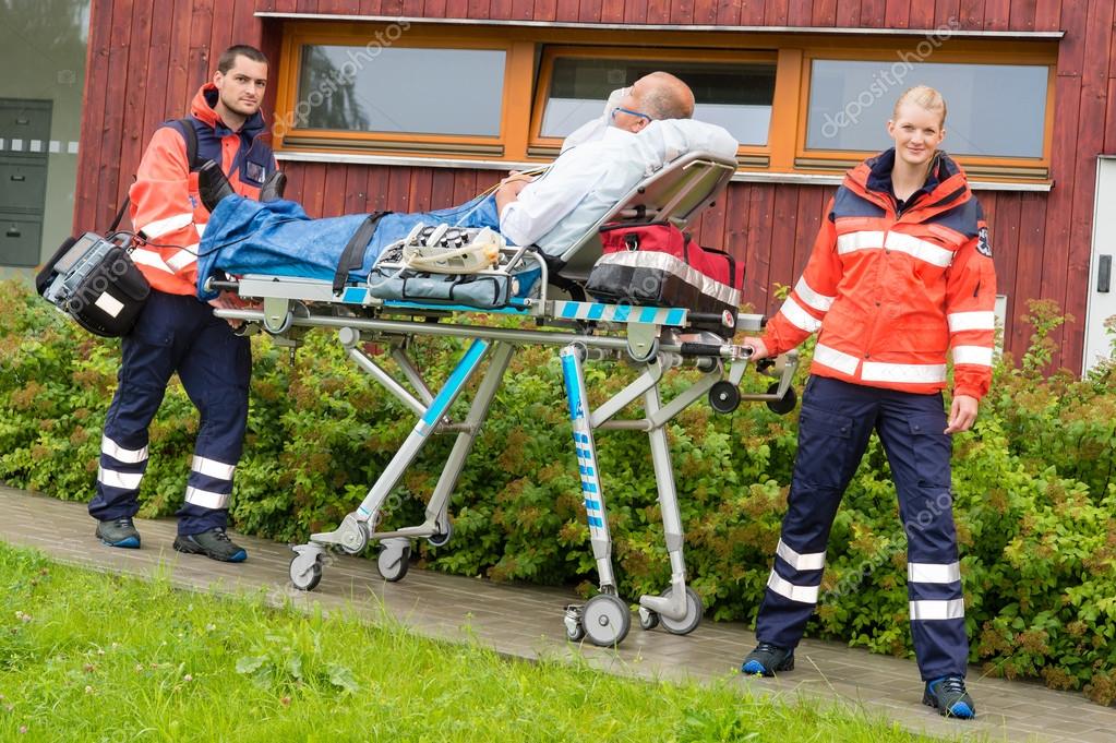 Paramedics with patient on stretcher ambulance aid — Stock Photo