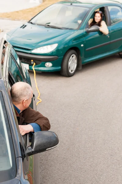 Mann hilft Frau, indem er ihr Auto zieht — Stockfoto
