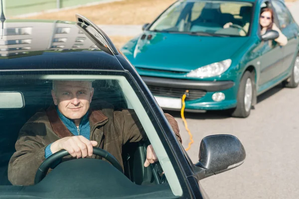 Hombre ayudando a la mujer tirando de su coche —  Fotos de Stock