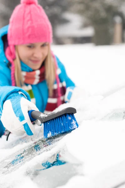 Donna pulire parabrezza auto utilizzando spazzola neve — Foto Stock