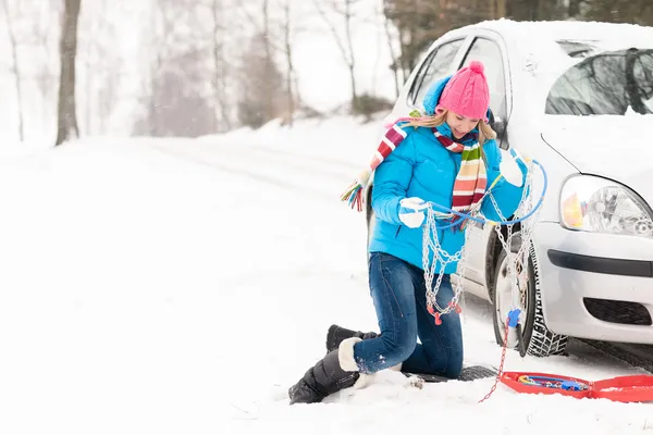 Vrouw met wintersneeuw auto tire chains — Stockfoto