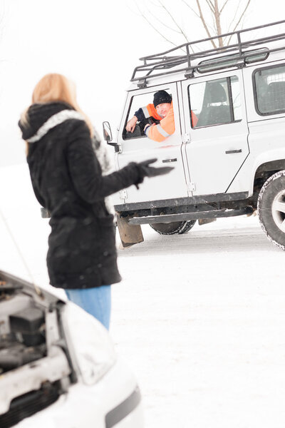 Woman having trouble with car snow assistance