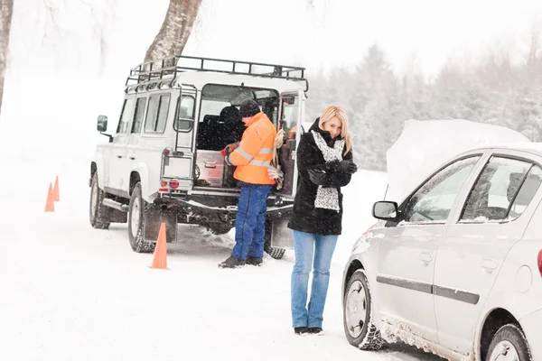 Meccanico aiutare la donna con la neve rotto auto — Foto Stock